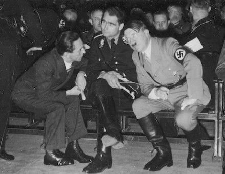 Adolf Hitler in conversation with minister of propaganda Joseph Goebbels and deputy fuhrer Rudolf Hess, December 1933. Potemkowska Aleksandra. Public Domain.